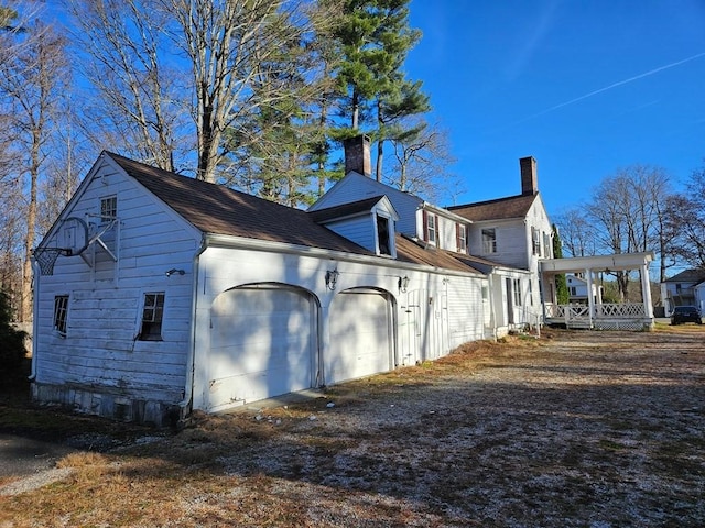 view of side of home featuring a garage and covered porch