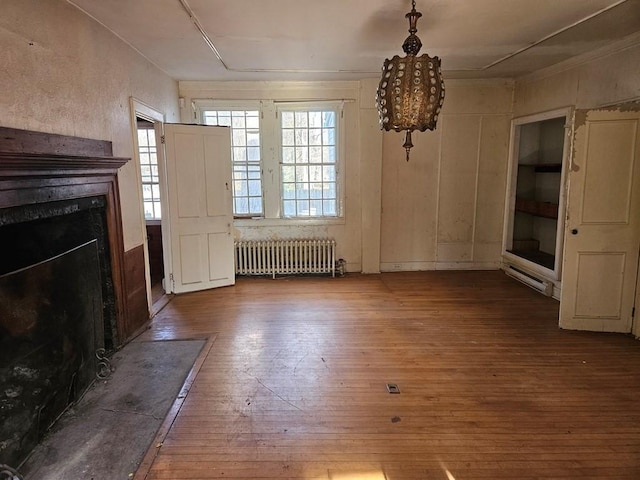 interior space featuring radiator, hardwood / wood-style flooring, and a premium fireplace