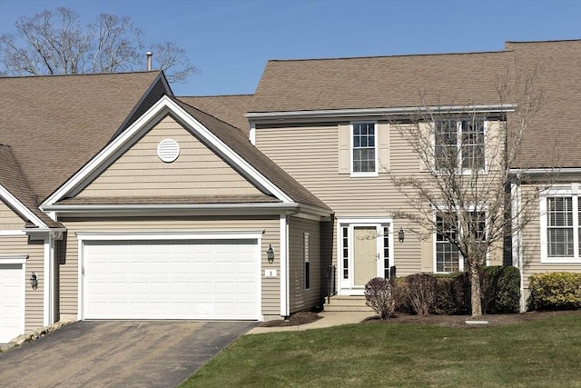 multi unit property with driveway, roof with shingles, and a garage