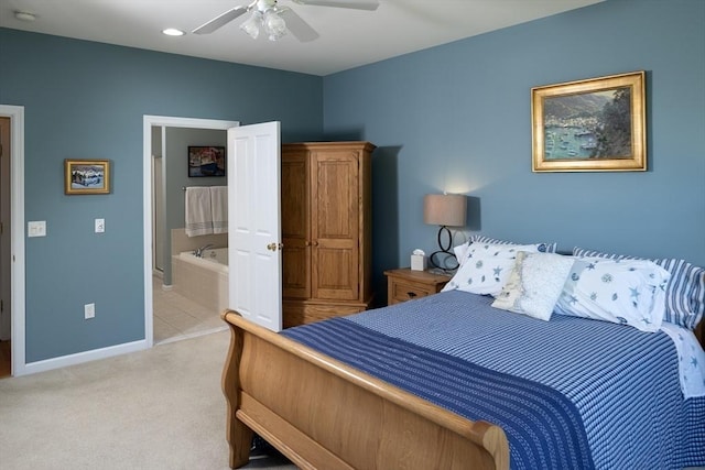 bedroom featuring light colored carpet, ceiling fan, baseboards, and connected bathroom