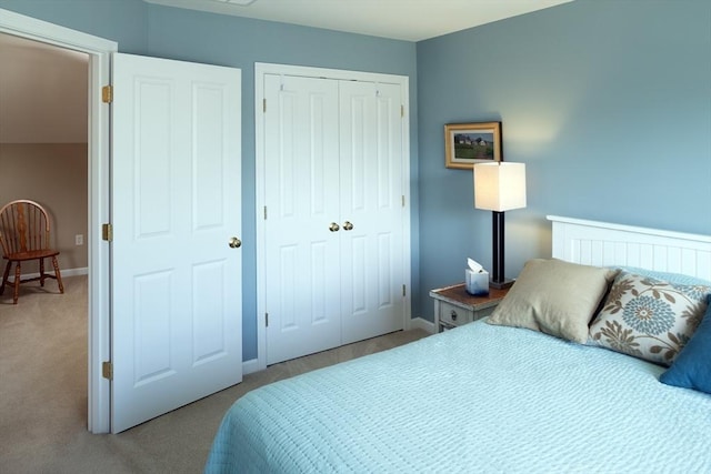 carpeted bedroom with a closet and baseboards