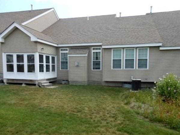 back of property featuring a yard