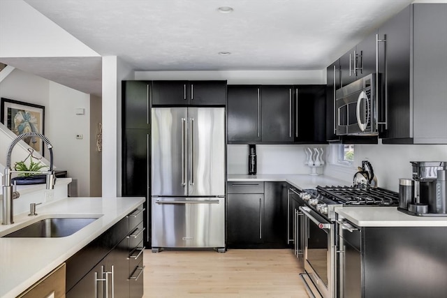 23 Matt Hoxie Trl Unit 23, Plymouth, MA 02360 - kitchen featuring appliances with stainless steel finishes, a sink, light wood-style flooring, dark cabinetry, and recessed lighting
