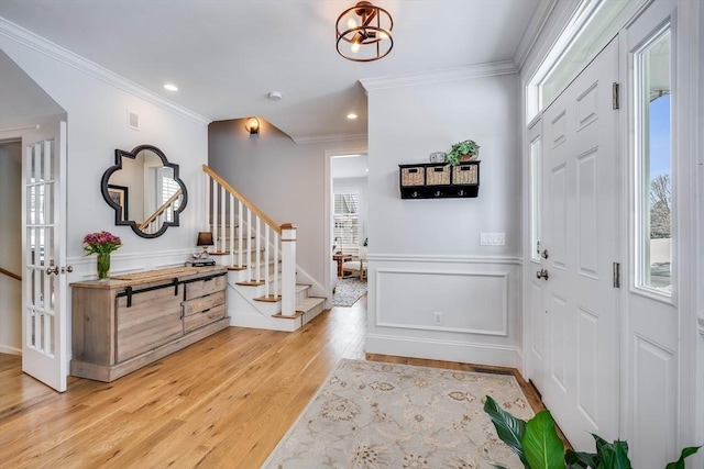 entryway featuring crown molding and light hardwood / wood-style floors