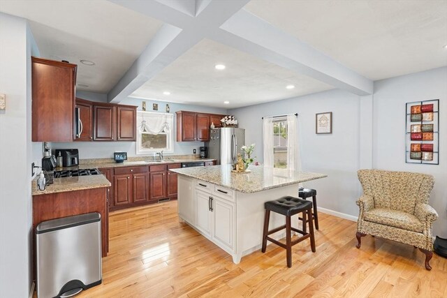 39 Doyle Ave, Dracut, MA 01826 - kitchen featuring stainless steel appliances, beamed ceiling, a breakfast bar area, light wood-style floors, and recessed lighting