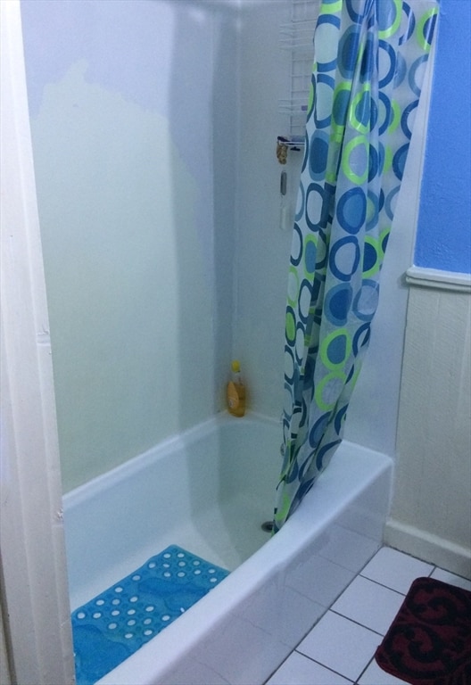 bathroom with shower / bath combo and tile floors