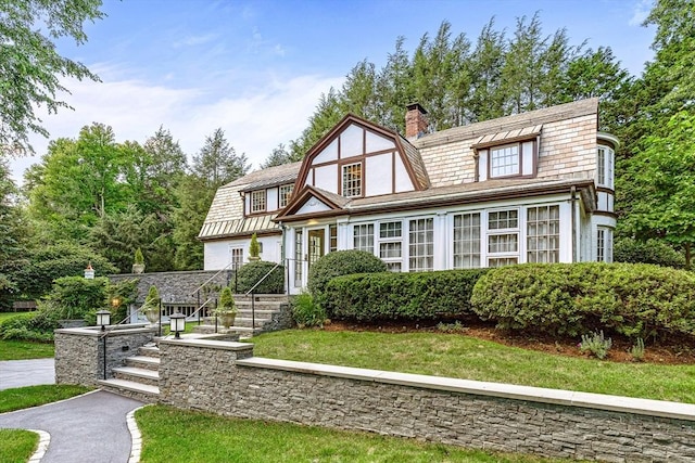 view of front of property featuring a chimney and a gambrel roof