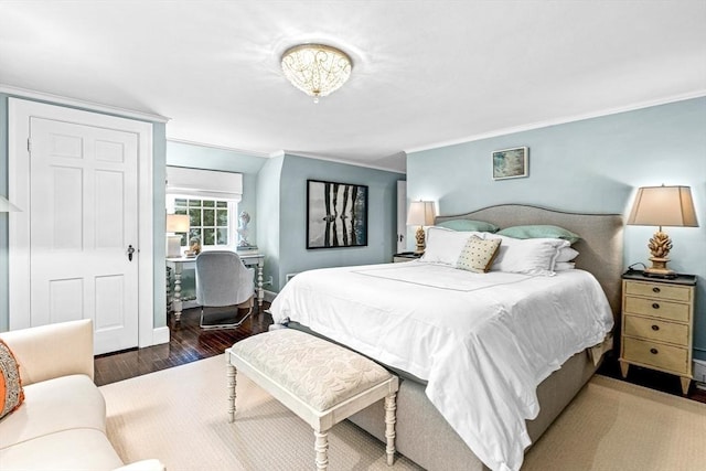 bedroom with crown molding, baseboards, and wood finished floors