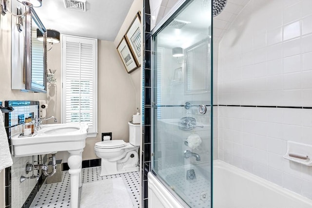 full bath with toilet, tile patterned flooring, visible vents, and bath / shower combo with glass door