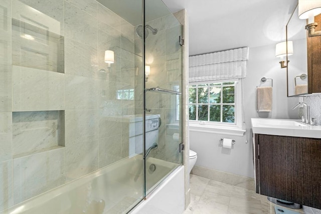 bathroom with toilet, bath / shower combo with glass door, vanity, baseboards, and marble finish floor