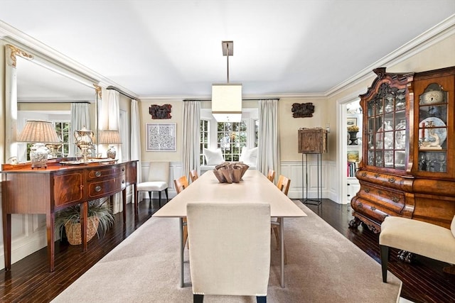 dining room with ornamental molding, dark wood-style flooring, wainscoting, and plenty of natural light