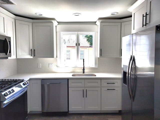 kitchen featuring dark hardwood / wood-style floors, white cabinetry, appliances with stainless steel finishes, and sink