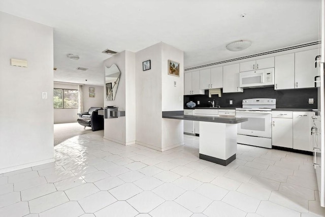 24 Crestview Dr Unit 24, Malden, MA 02148 - kitchen with white appliances, open floor plan, dark countertops, and white cabinetry