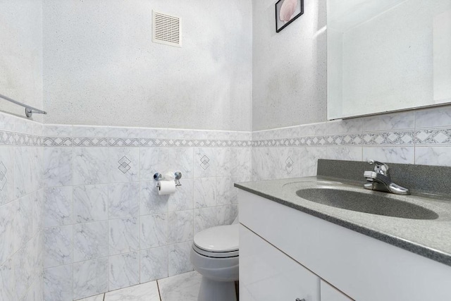 24 Crestview Dr Unit 24, Malden, MA 02148 - half bathroom featuring vanity, tile walls, a wainscoted wall, and marble finish flooring