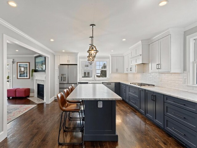 kitchen with a sink, appliances with stainless steel finishes, white cabinetry, and light countertops