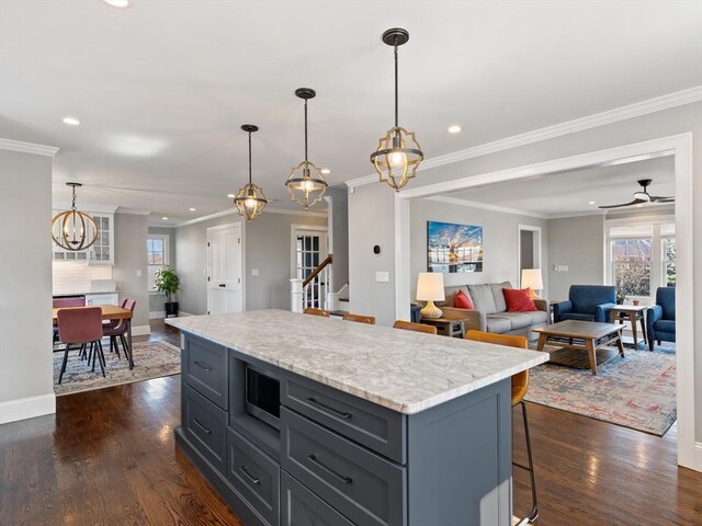 kitchen featuring a breakfast bar, a chandelier, dark wood finished floors, recessed lighting, and a kitchen island