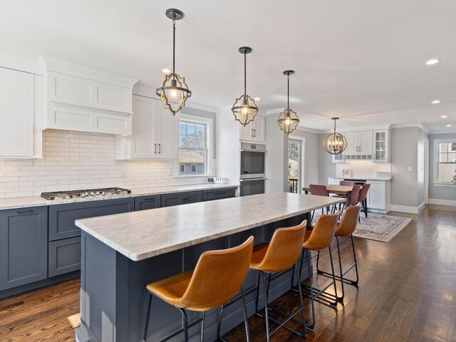 kitchen featuring decorative backsplash, recessed lighting, light countertops, a center island, and stainless steel appliances