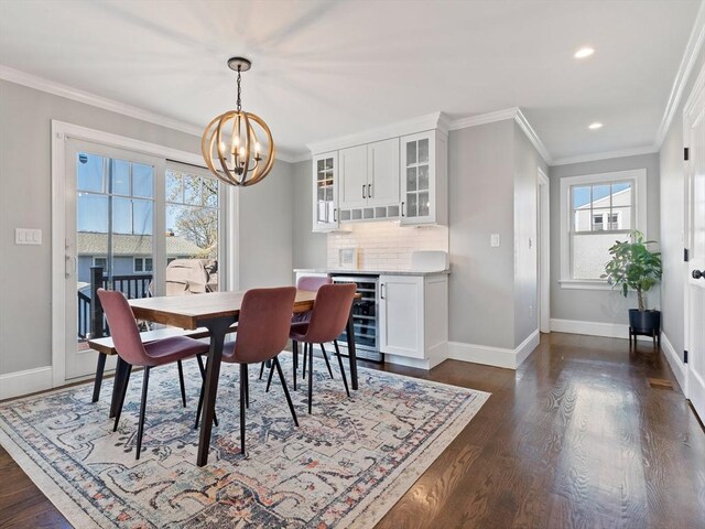 dining area with beverage cooler, an inviting chandelier, ornamental molding, and a wealth of natural light
