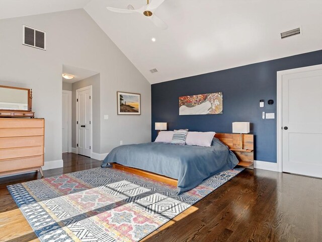 bedroom with visible vents, wood finished floors, and high vaulted ceiling