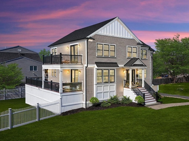 view of front of house featuring fence, a balcony, and a front lawn