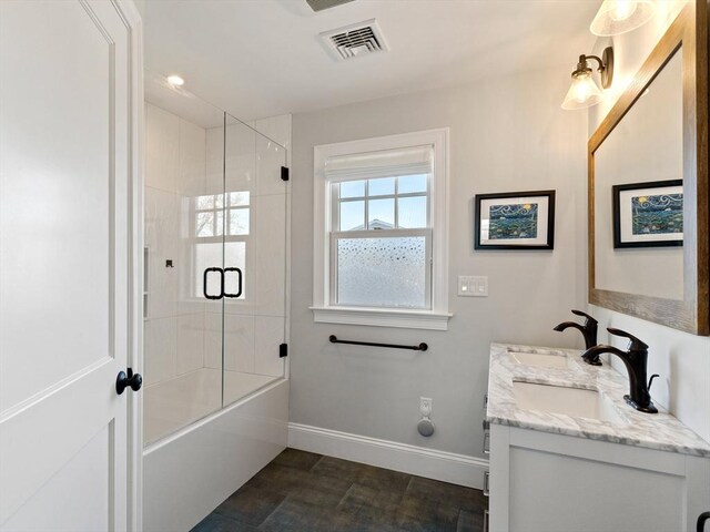 full bath featuring visible vents, a sink, baseboards, and double vanity