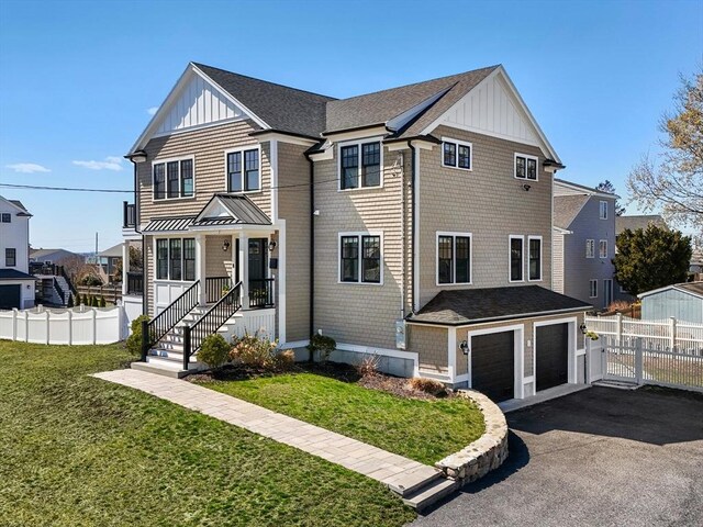 view of front of house with board and batten siding, an attached garage, fence, and aphalt driveway