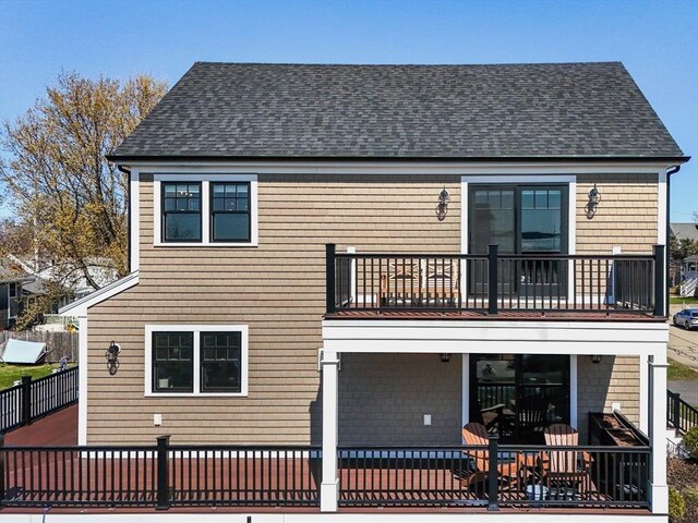 back of property featuring a shingled roof and a balcony