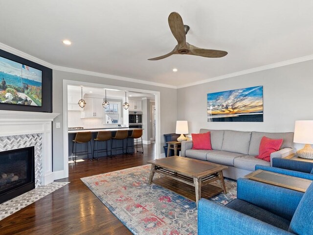 living room featuring crown molding, recessed lighting, a ceiling fan, and dark wood-style flooring