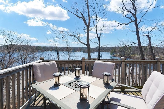 wooden deck featuring outdoor dining area and a water view