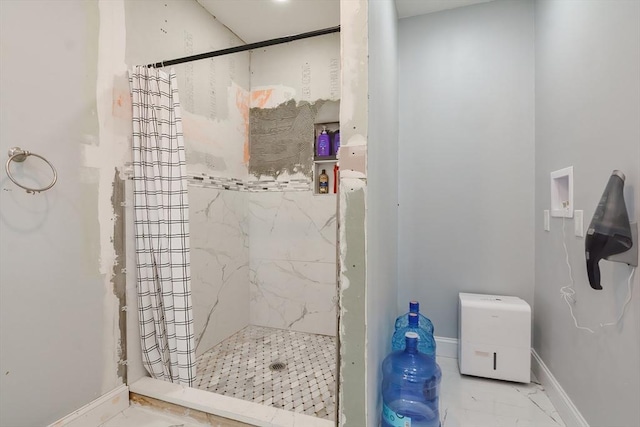 bathroom featuring a shower stall, baseboards, and marble finish floor