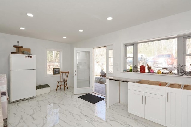 kitchen with marble finish floor, white cabinets, recessed lighting, and freestanding refrigerator