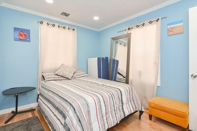 bedroom with recessed lighting, crown molding, baseboards, and wood finished floors
