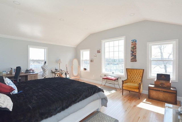 bedroom with multiple windows, light wood-style floors, and lofted ceiling