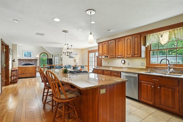 105 Old Barn Path, Marshfield, MA 02050 - kitchen featuring stainless steel appliances, a sink, light stone counters, brown cabinets, and a center island