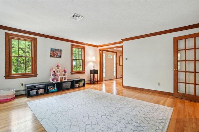 105 Old Barn Path, Marshfield, MA 02050 - rec room featuring wood finished floors, ornamental molding, a baseboard radiator, baseboards, and a textured ceiling