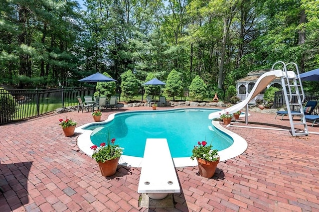 28 Old Farm Rd, Hopkinton, MA 01748 - view of pool with a water slide, a diving board, a patio, view of wooded area, and outdoor dining space