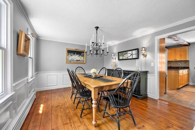 28 Old Farm Rd, Hopkinton, MA 01748 - dining area featuring a baseboard heating unit, hardwood / wood-style floors, a wainscoted wall, a decorative wall, and crown molding