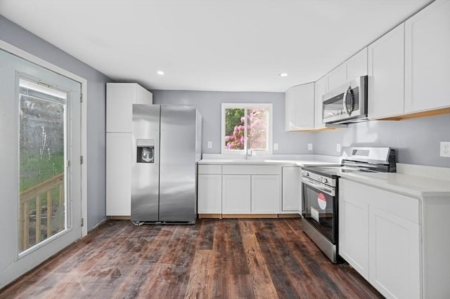 628 Rindge Rd, Fitchburg, MA 01420 - kitchen featuring stainless steel appliances, dark wood-style flooring, light countertops, white cabinetry, and recessed lighting