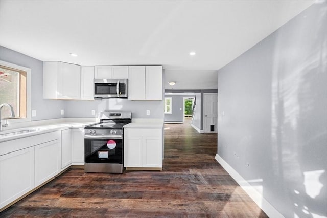 628 Rindge Rd, Fitchburg, MA 01420 - kitchen with stainless steel appliances, a sink, dark wood-style flooring, white cabinets, and recessed lighting