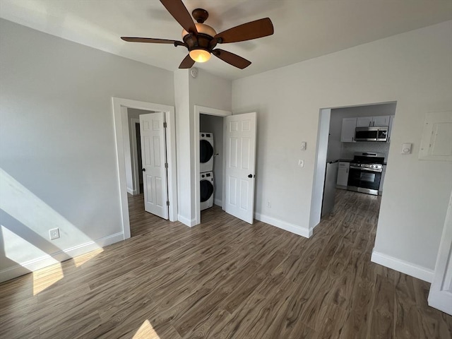 110 Old Harbor St, Boston, MA 02127 - unfurnished room with stacked washing machine and dryer, dark wood-style flooring, ceiling fan, and baseboards