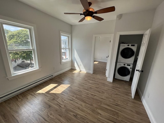 110 Old Harbor St, Boston, MA 02127 - washroom with stacked washing machine and dryer, healthy amount of natural light, baseboard heating, and wood finished floors