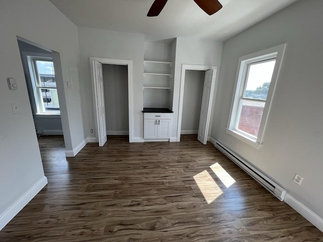 110 Old Harbor St, Boston, MA 02127 - unfurnished bedroom with baseboard heating, multiple windows, and dark wood-type flooring
