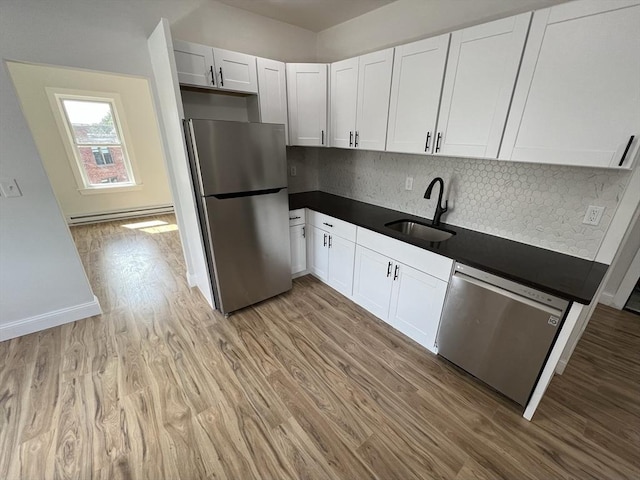 110 Old Harbor St, Boston, MA 02127 - kitchen with appliances with stainless steel finishes, a sink, light wood finished floors, and a baseboard heating unit