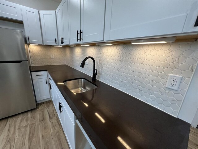 110 Old Harbor St, Boston, MA 02127 - kitchen featuring freestanding refrigerator, a sink, dark countertops, light wood-style floors, and tasteful backsplash