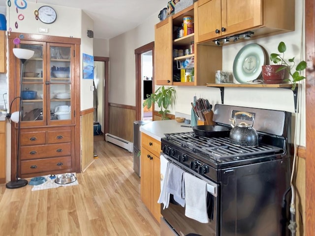 kitchen featuring a wainscoted wall, baseboard heating, light wood-type flooring, open shelves, and range with gas cooktop