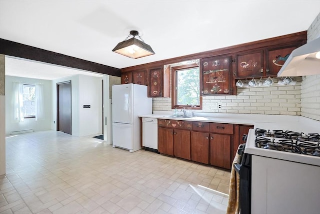 kitchen featuring white appliances, a baseboard radiator, light countertops, a sink, and backsplash
