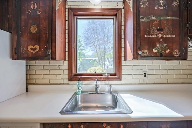 interior space featuring light countertops, a sink, dark brown cabinetry, and tasteful backsplash
