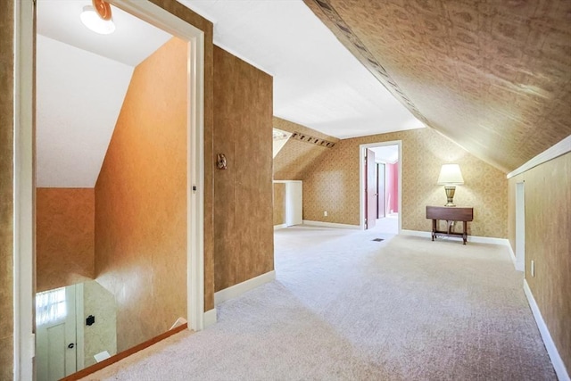 bonus room featuring vaulted ceiling and carpet flooring