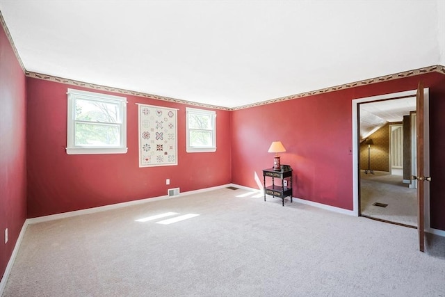 carpeted empty room featuring baseboards and visible vents
