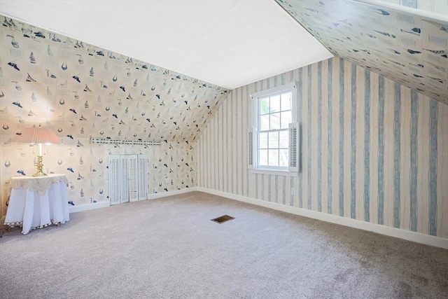 additional living space featuring visible vents, carpet flooring, and vaulted ceiling